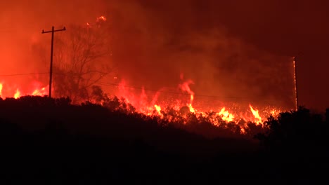 the cave fire wildfire burns at night and consumes acres of brush in the hills above santa barbara california