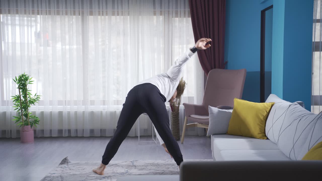 젊은 보디빌더가 스포츠 전에 부상을 예방하기 위해 허리 스트레칭을 하고 있습니다.