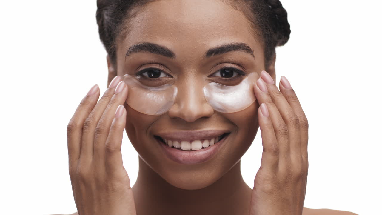 mujer aplicando parches en los ojos