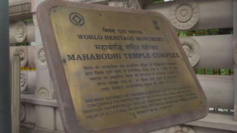 Wide-shot-of-information-engraved-in-English-and-Hindi-at-the-entrance-of-Mahabodhi-Temple-Complex-World-Heritage-site,-Bodhgaya,-Bihar,-India