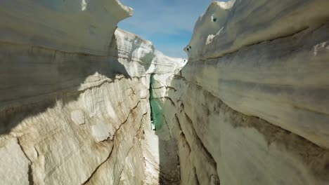 aerial view thorugh a ice crevasse, cracked on the ice surface of an icelandic glacier, on a sunny day