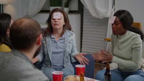 amigos multiétnicos bebiendo cerveza mientras juegan al juego de adivinar quién