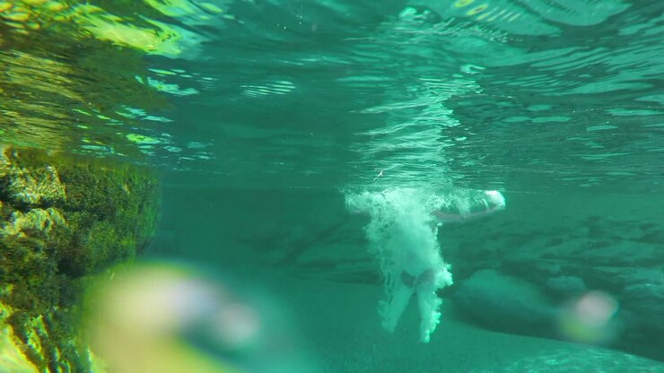 Woman in a red bikini swimming underwater