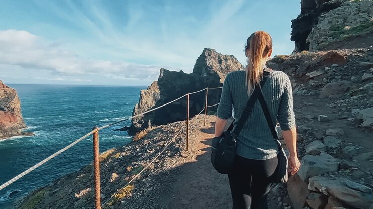 Ponta de São Lourenço, Madeira: Reisende geht einen Pfad an einer Klippe entlang und blickt auf den Atlantik in Portugal