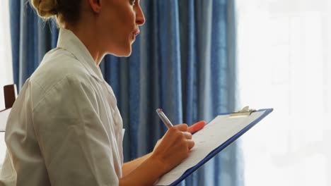 smiling doctor writing on clipboard 4k