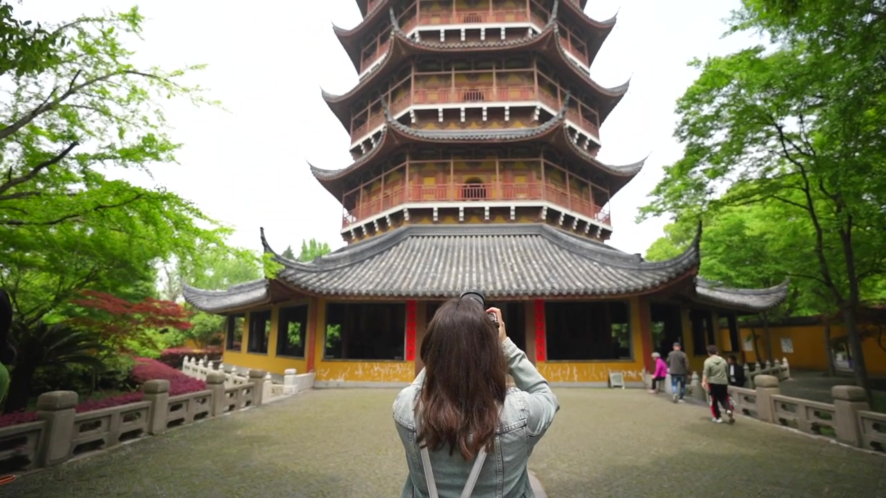 Giovane donna con zaino che scatta una foto di un'antica pagoda a Suzhou, Cina