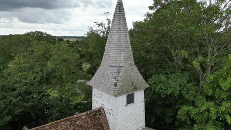 an ascending boom shot of the steeple of all saints church in west stourmouth