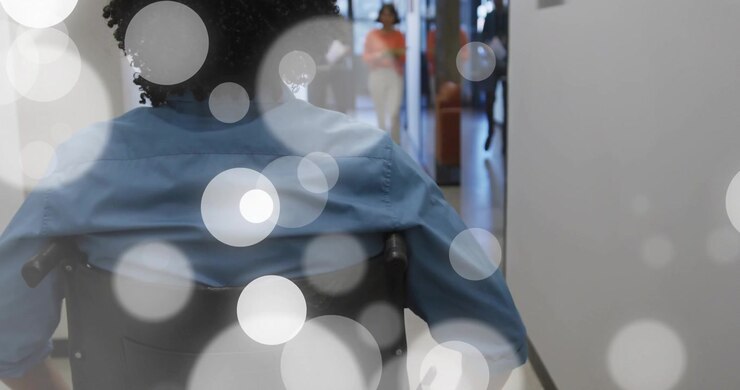 Wheelchair user pushing rims through office, drifting overlays marking glass doors, meeting team