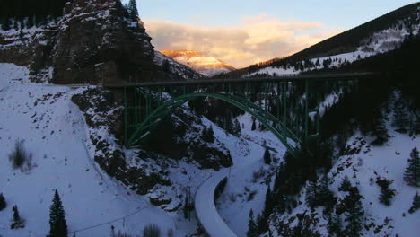 Aerial-Cinematic-drone-Vail-Avon-Red-Cliff-Iconic-Colorado-Bridge-mid-winter-late-sunset-pan-upward-movement