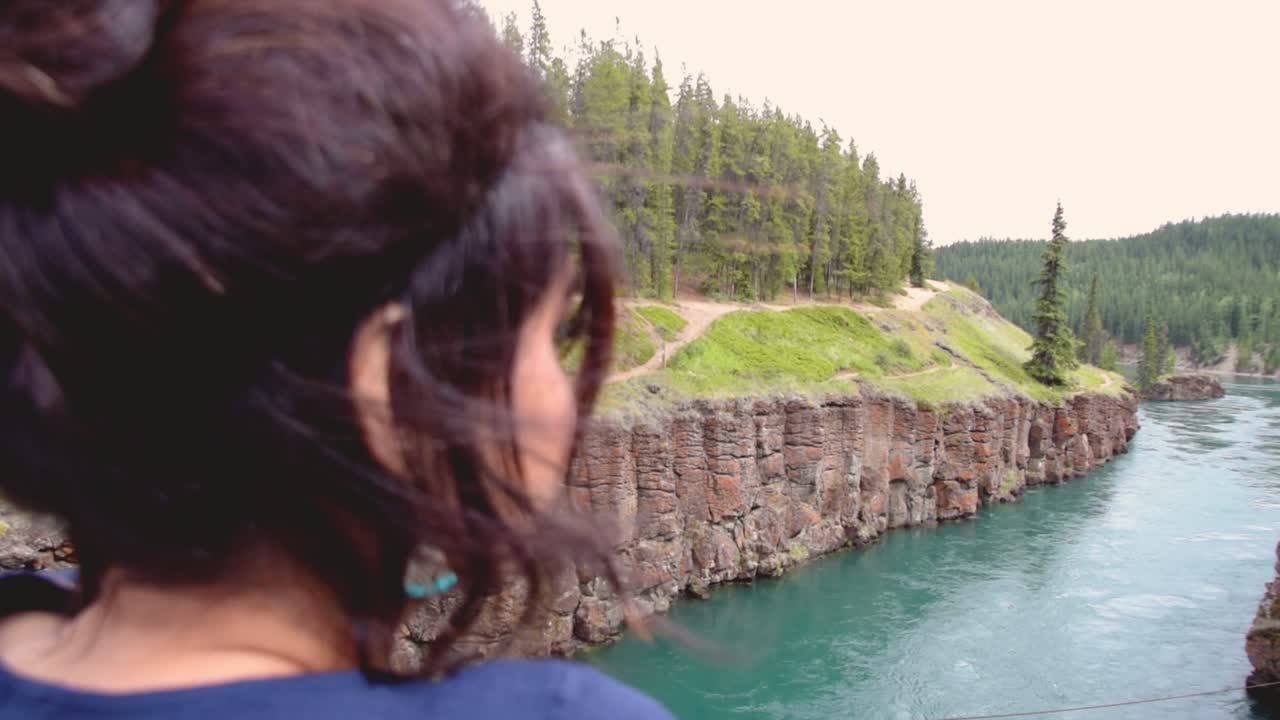 Indian woman looks out onto Yukon River at Miles Canyon, close up