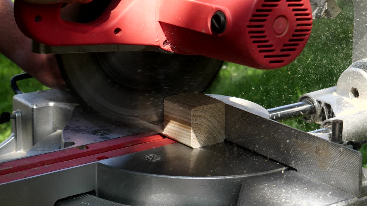 Footage of a circular saw that sawing through a piece of wood