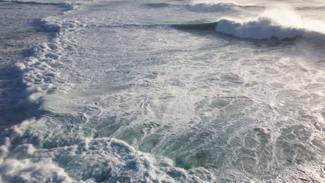 an aerial view of the raging and foaming waves of the atlantic rolling in all directions