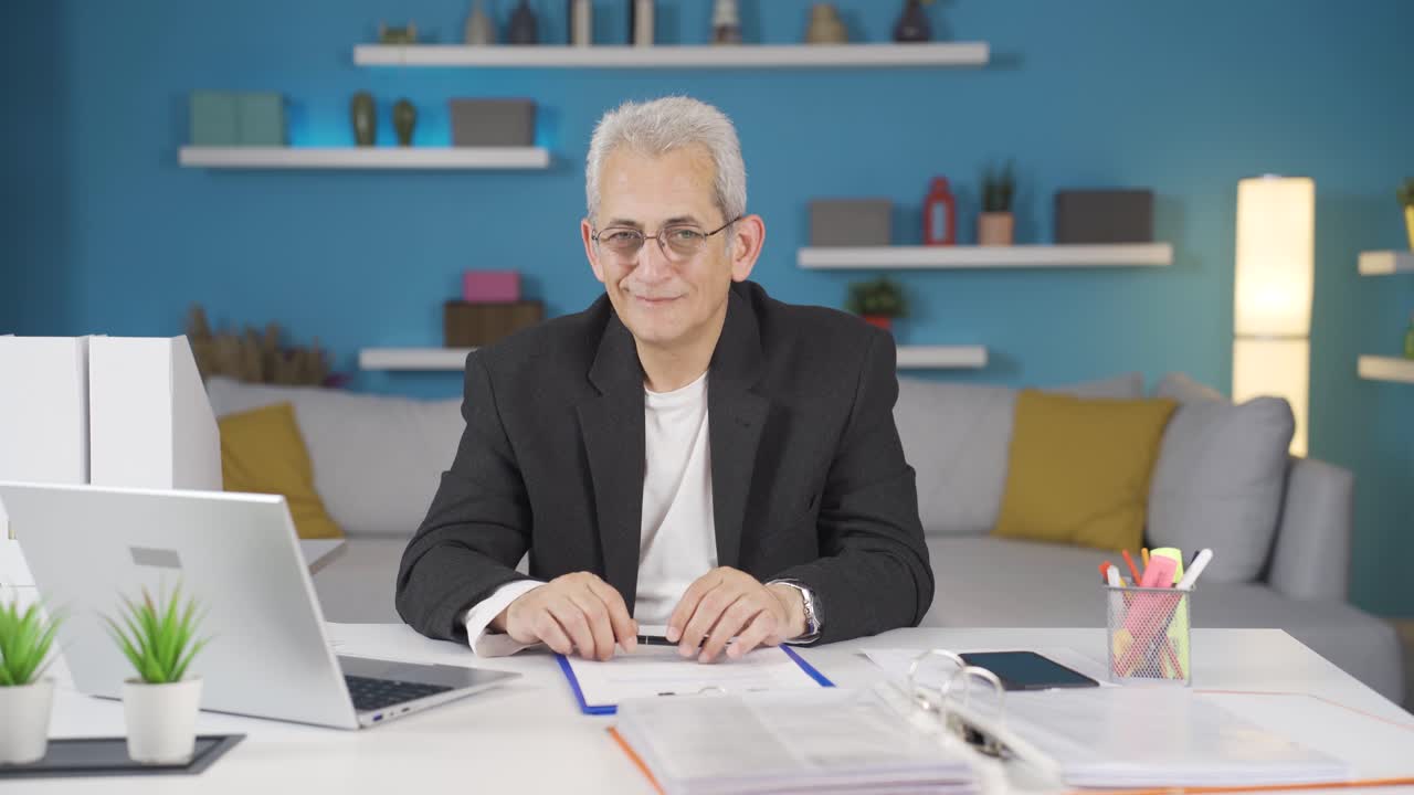 trabajador de oficina en casa hombre mirando con expresión satisfecha.