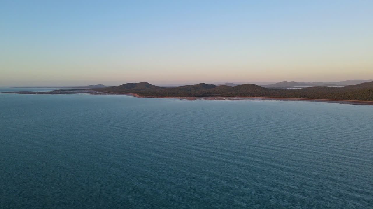 해질 무렵 멀리 클레어뷰 마을이 있는 바다의 잔잔한 바다 - 호주 퀸즐랜드에 있는 이삭 지역의 바다