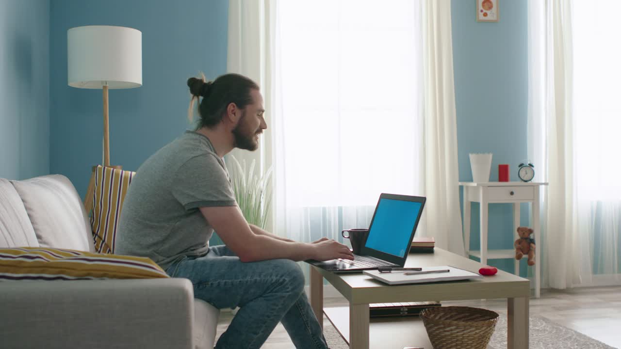 남자가 크로마 키를 가진 노트북을 통해 이야기하고 있습니다.