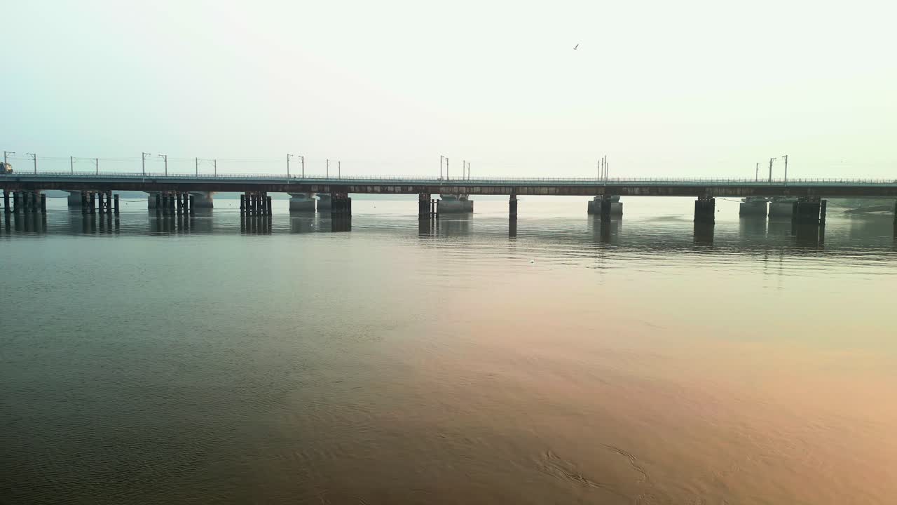 train going on vasai creek bridge side wide drone view.