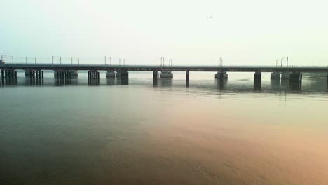 train going on vasai creek bridge side wide drone view.