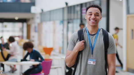 retrato de un estudiante universitario sonriente en un ocupado edificio del campus comunal