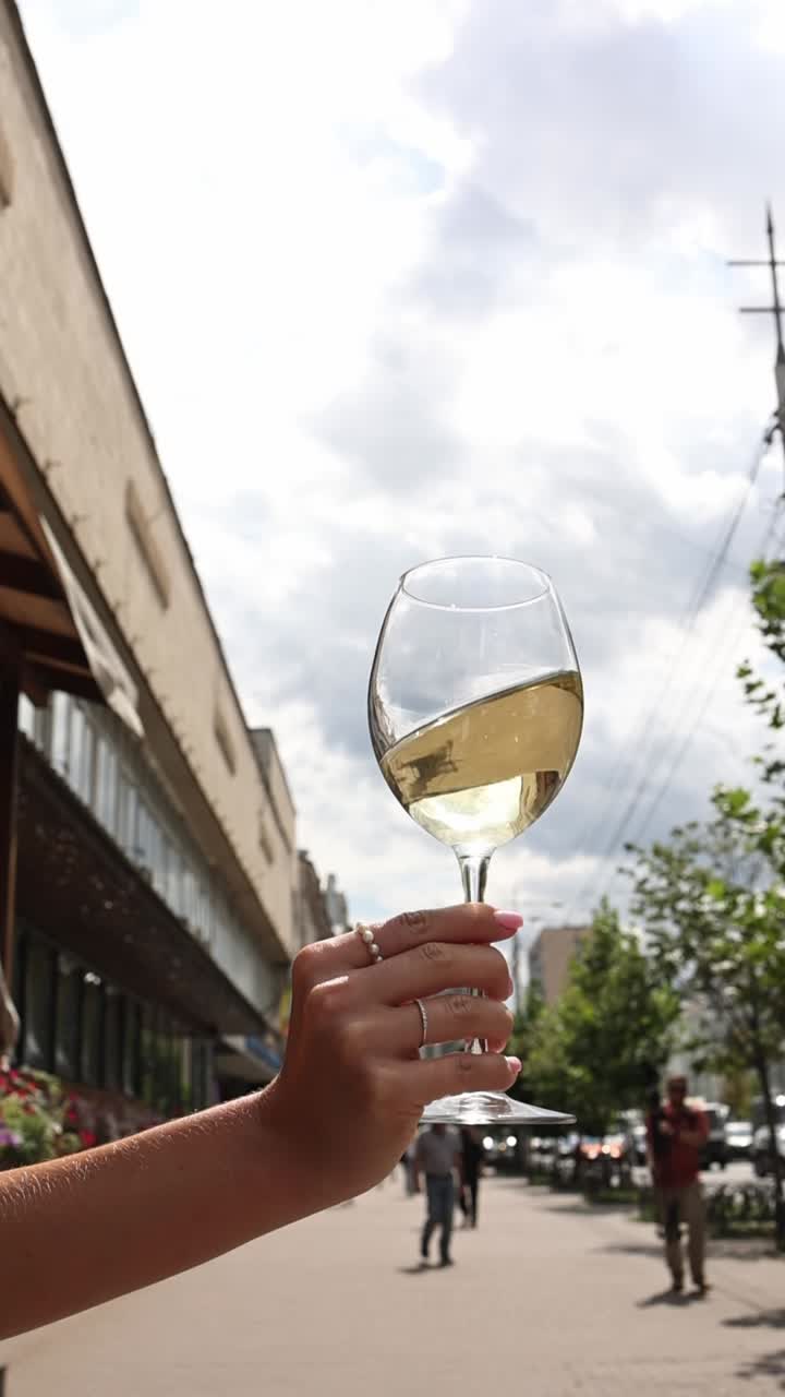 도시 거리에서  와인 한 잔을 들고 있는 여자
