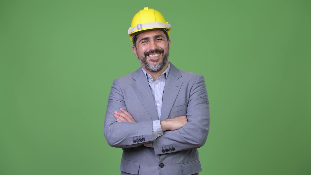 Handsome Persian bearded businessman as engineer with arms crossed