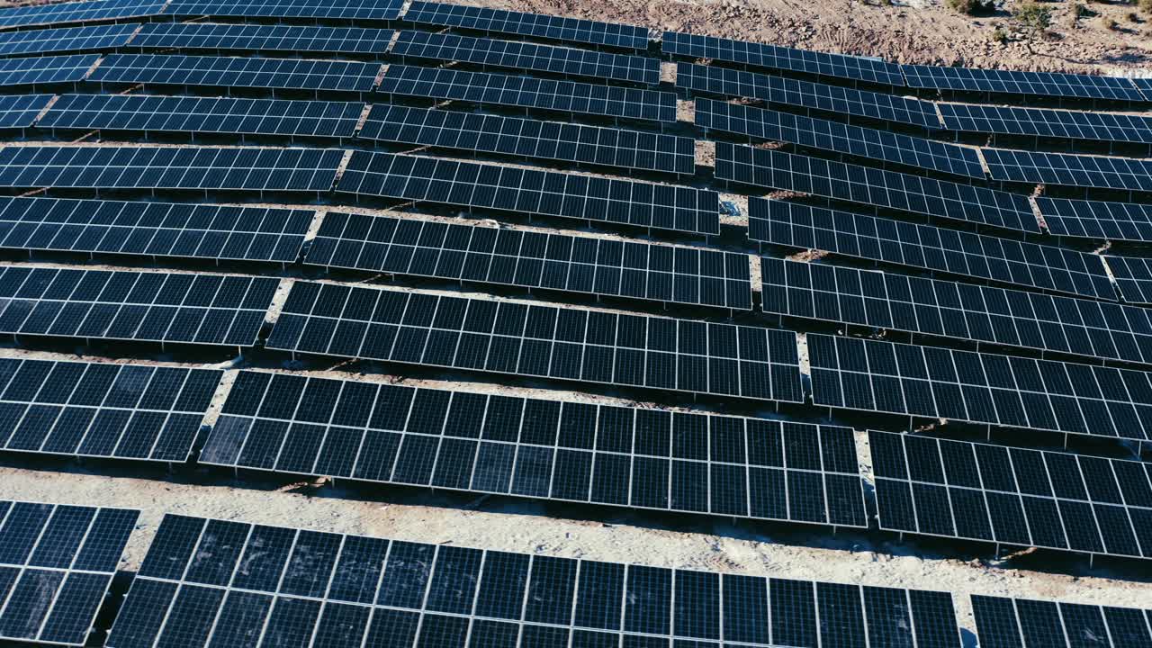 Ripresa con drone di file di pannelli solari in un impianto fotovoltaico.