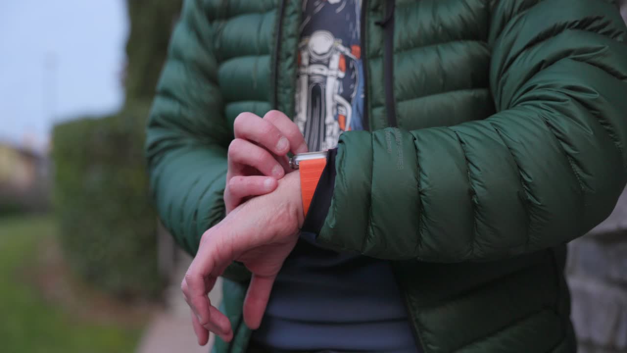 un hombre utilizando las características del reloj de manzana ultra 2 en su muñeca - de cerca