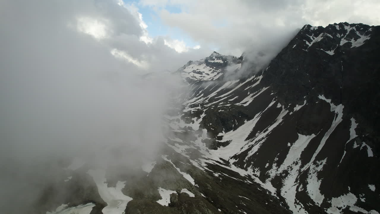 dolomitas nevadas escarpadas con nubes tenues, vuelo de drones de altitud, italia
