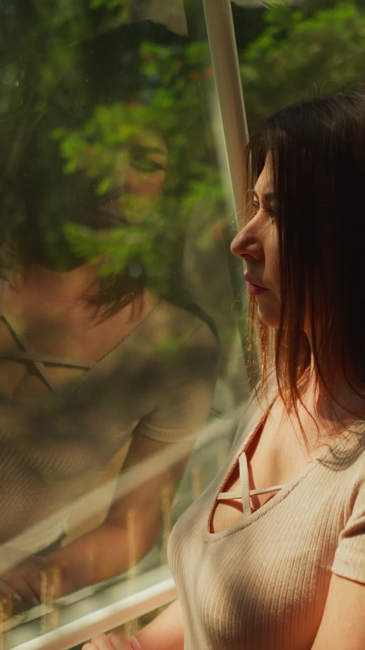 la señora disfruta de la vista del denso bosque de pie en la terraza ventana clara. la mujer disfruta del magnífico lugar para las vacaciones. concepto de soledad y recreación en la naturaleza en glamping