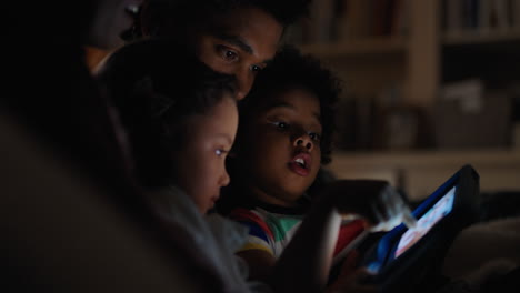 familia feliz usando una tableta con los niños madre y padre viendo una película con los niños en la tecnología de pantalla táctil disfrutando de una noche relajante antes de acostarse