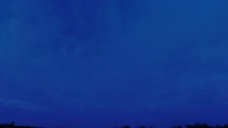 background: day to night time-lapse clouds drift in deepening blue sky