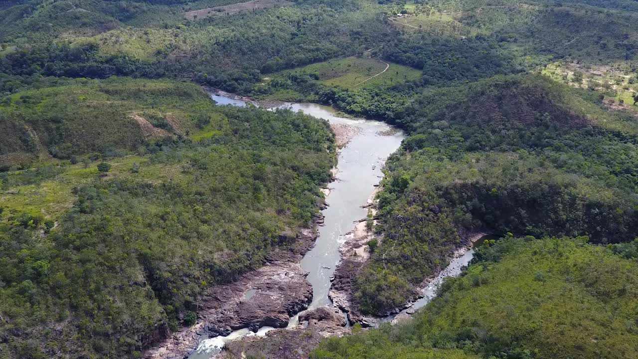 Tilt down shot over a tropical landscape as a river separates in two