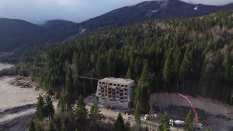 Construction-site-in-the-middle-of-the-forest-with-big-mountain-in-the-background