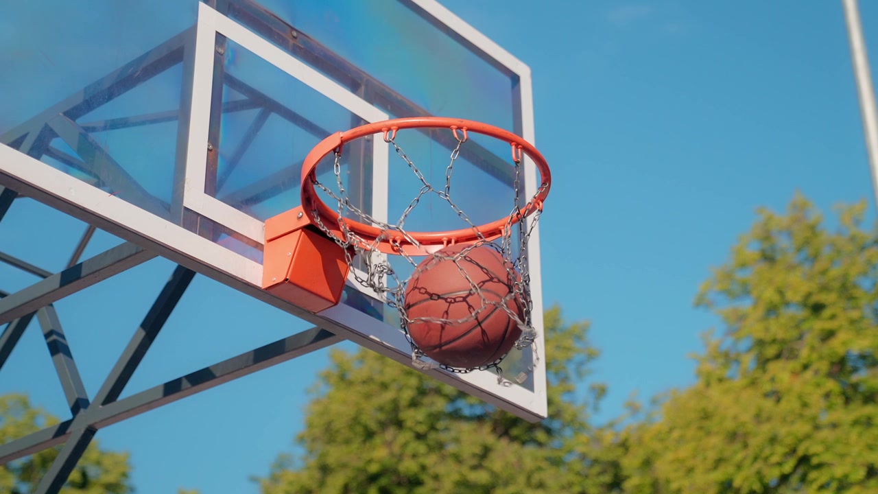 Palla da basket che entra con successo nel canestro con rete a catena