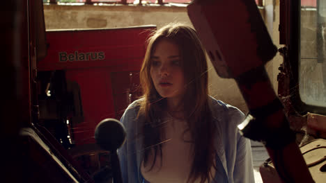 young woman inspecting tractor parts