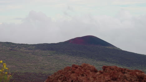 4k lookout of volcanic mountain over crater valley with rocky foreground, mauna kea, hawaii, slow motion