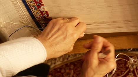 hand weaving a carpet
