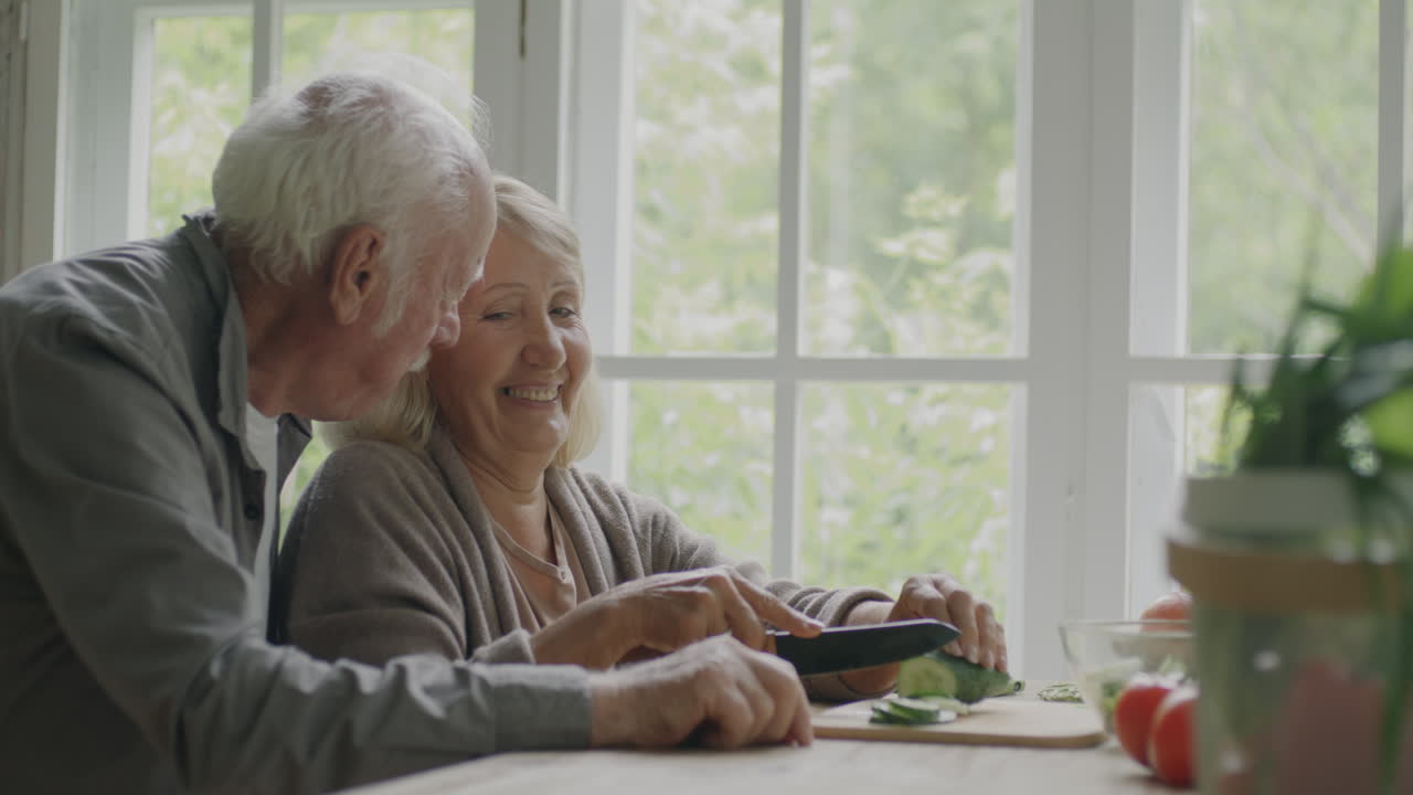 행복한 고등 부부가 함께 요리하고 있습니다.