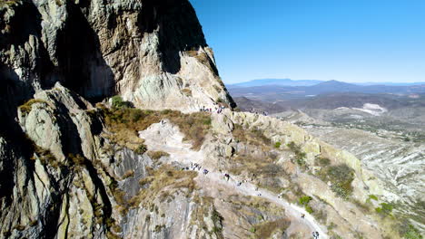 Drohnenaufnahme-Von-Menschen,-Die-Zum-Felsen-Von-Bernal-Aufsteigen