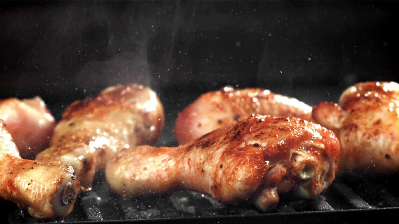 Fusi di pollo che sfrigolano su una griglia per barbecue