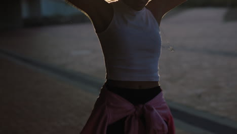 dancing-woman-young-hispanic-hip-hop-dancer-in-city-enjoying-fresh-urban-freestyle-dance-moves-practicing-expression-at-sunset-close-up