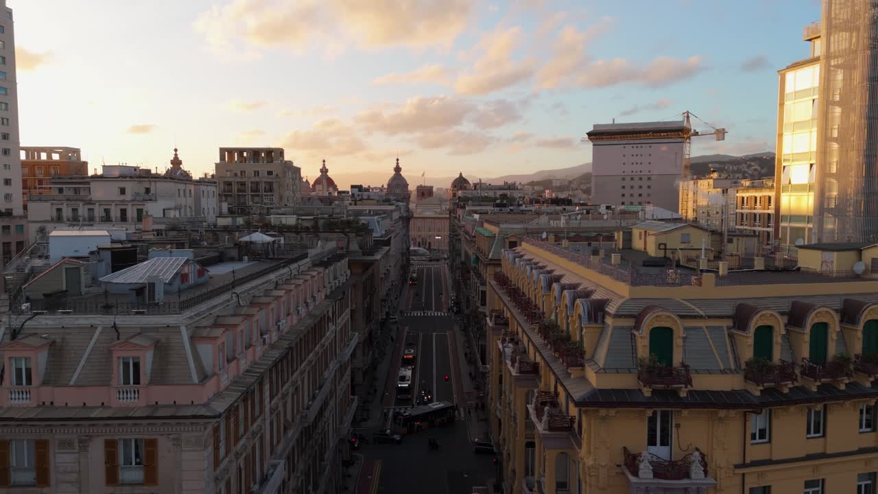 Volo di drone aereo sopra le strade di quartieri tradizionali italiani, skyline al tramonto in Liguria
