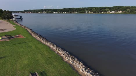 Un-Dron-Se-Eleva-Por-Encima-De-Un-Banco-De-Un-Parque-Vacío-Con-Vistas-Al-Poderoso-Río-Mississippi