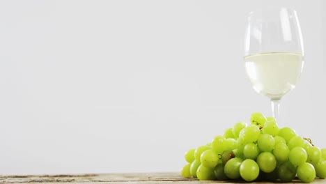 uvas y vino blanco en una tabla de madera