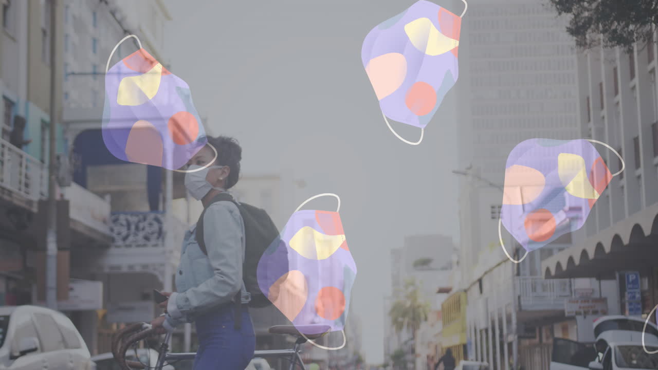 여러 개의 얼굴 마스크가 거리를 가로지르는 자전거와 함께 얼굴 마스크를 쓰고 있는 여성을 향해 움직이고 있습니다.