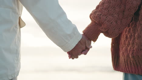 couple, closeup of hand holding and beach