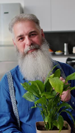 older man with a beard and a houseplant