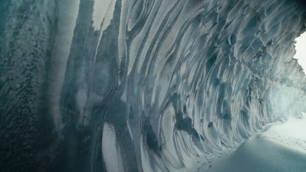 hermoso túnel de cueva de hielo azul con nieve y salida gigante pan lento