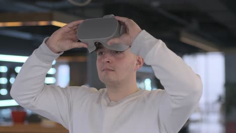 young man wearing virtual reality headset in modern interior.