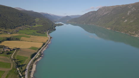 aerial shot flying over a river snaking through a mountain valley in norway