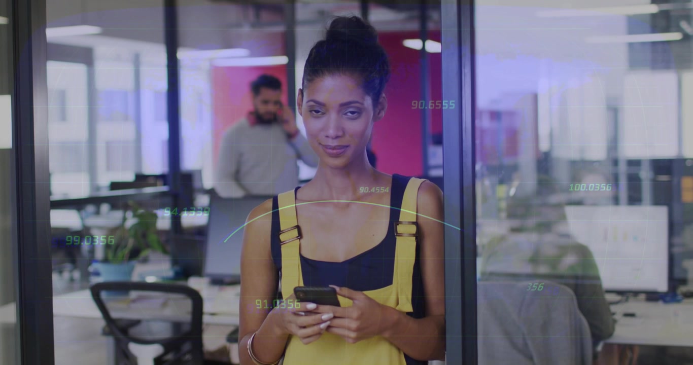Woman typing on smartphone against glass in office, activating animated data overlays for analytics